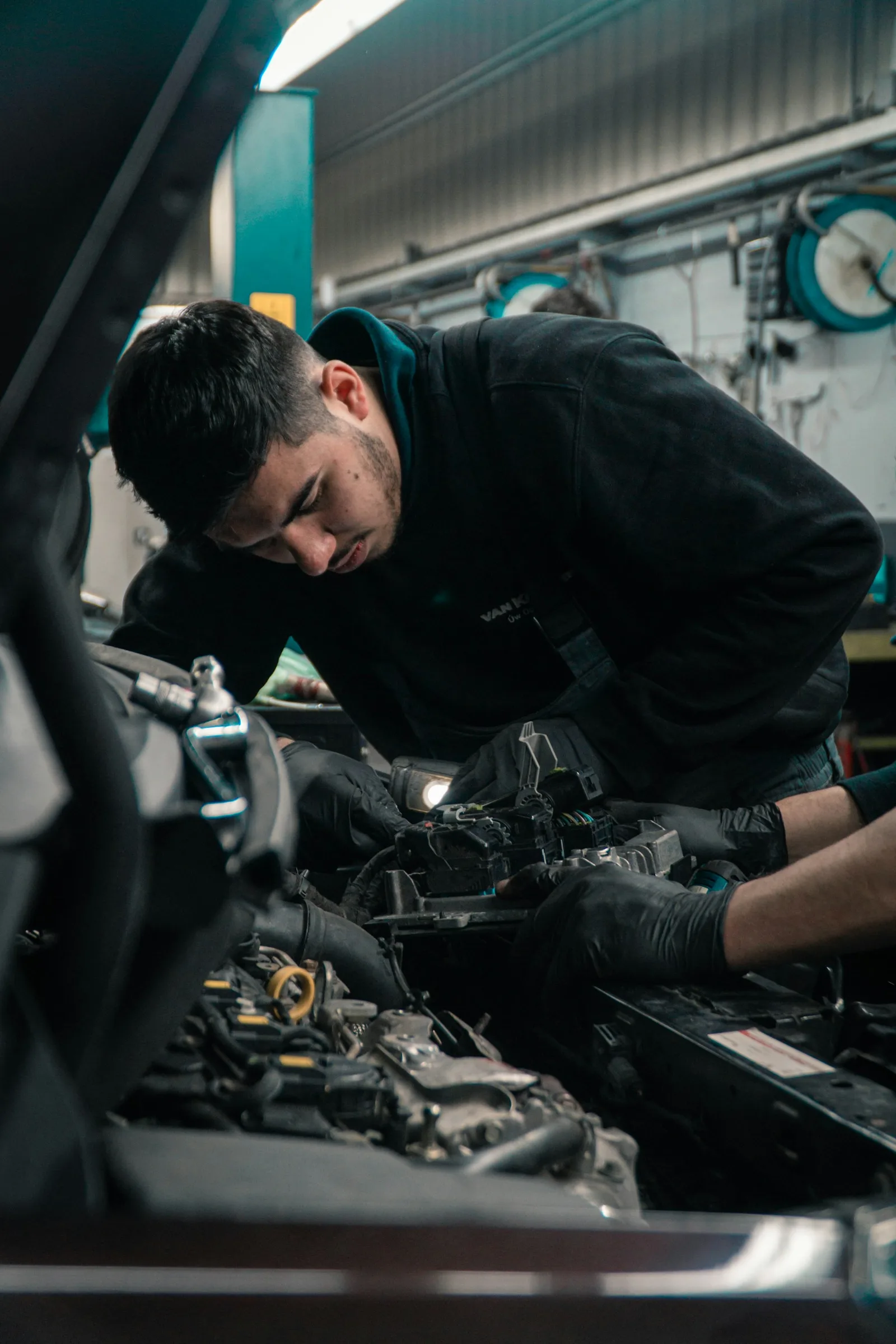 Automotive technician inspecting a vehicle in a workshop